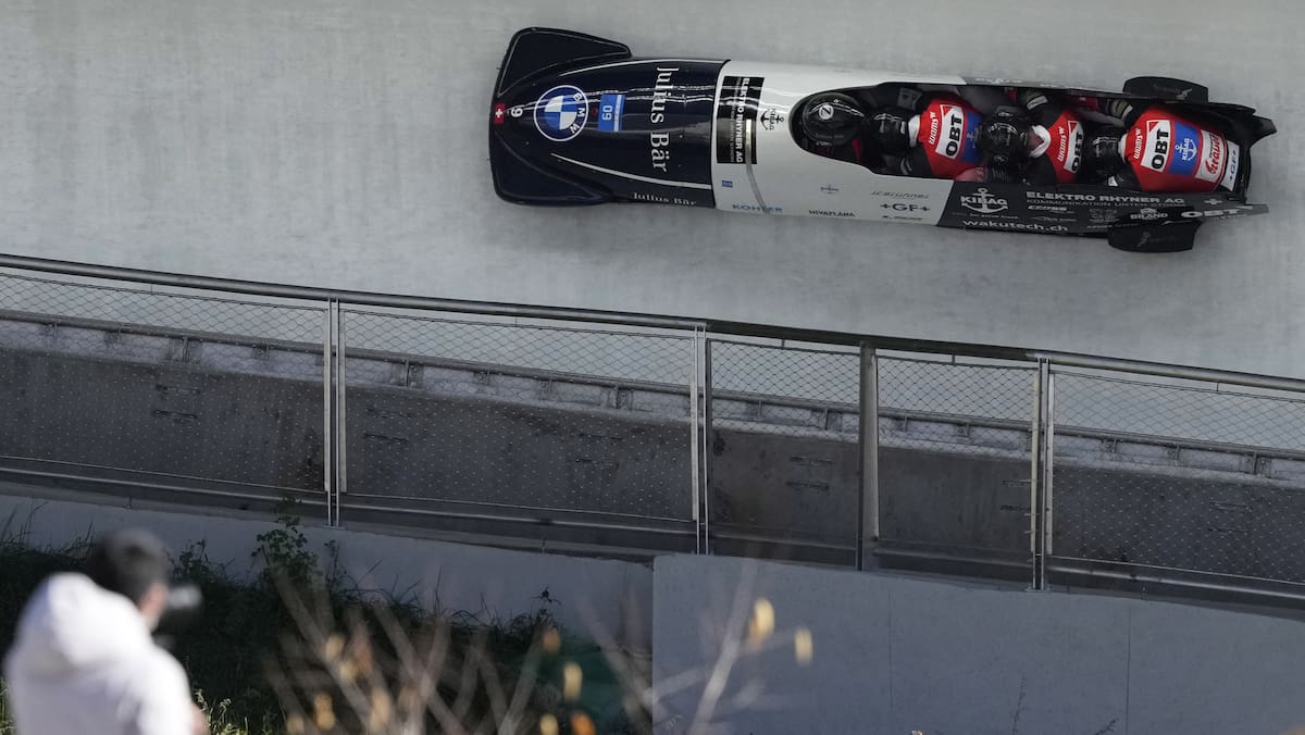 People watch as Michael Vogt, Alain Knuser, Cyril Bieri, and Sandro Michel of Switzerland compete in the four-man bobsleigh during an IBSF Sanctioned Race, a test event for the 2022 Winter Olympics, at the Yanqing National Sliding Center in Beijing, Tuesday, Oct. 26, 2021. (AP Photo/Mark Schiefelbein)